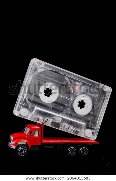 Music Concept Red Truck and Audio Music Tape\
on a Black Background