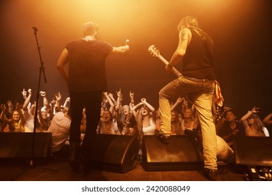 Music, concert and band on a stage with crowd for performance with lighting equipment at party. Event, entertainment and group of musicians at festival, disco or rave with energy for fans or audience - Powered by Shutterstock