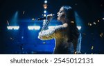 Music Contest: Beautiful Pop Music Artist Performing a Hit Song on Stage in Front of a the Camera. Her Charismatic Stage Presence and Lyrics Electrify the Diverse Music Fans