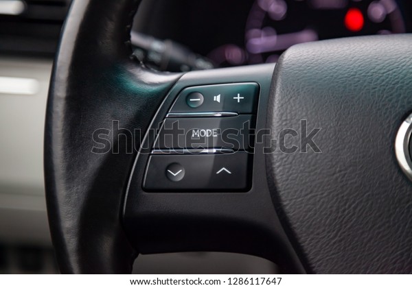 Music control\
buttons via bluetooth on the steering wheel of the car close-up,\
\