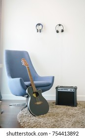 Music Corner In The Living Room With Retro Style Armchair, Headphones And Guitar