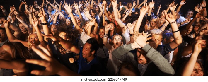 Music, dance and party with crowd at concert for rock, live band performance or festival. New year, energy and disco with audience of fans listening at celebration for techno, rave or nightclub event - Shutterstock ID 2266047749