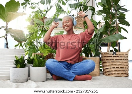 Music, dance and radio with a black woman in her home by plants while streaming an audio playlist. Freedom, headphones and subscription service with a carefree young female person in her house