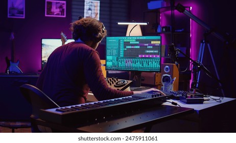 Music engineer using usb stick to edit and add sound effects on audio recording, adjusted volume levels. Artist doing mixing and mastering technique on soundboard, plays piano. Camera B. - Powered by Shutterstock