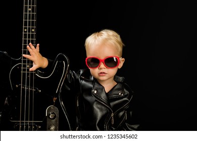 Music For Everyone. Adorable Small Music Fan. Small Musician. Little Rock Star. Child Boy With Guitar. Little Guitarist In Rocker Jacket. Rock Style Child. Rock And Roll Music Performer.