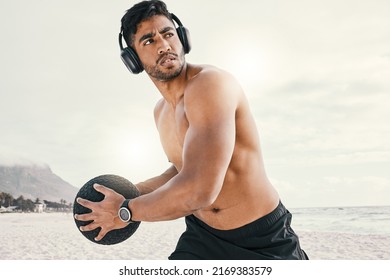 Music And Exercise, Now Thats A Good Combination. Shot Of A Sporty Young Man Wearing Headphones While Exercising Outside With A Medicine Ball.