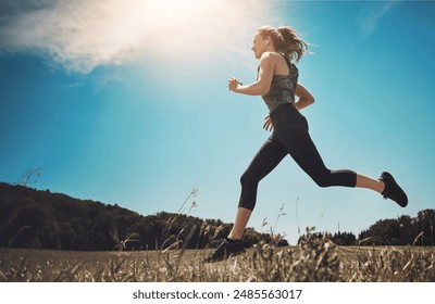 Music, exercise and woman running at park for healthy body, wellness or fitness workout. Earphones, cardio and trail runner training in nature for race, marathon and low angle outdoor with athlete