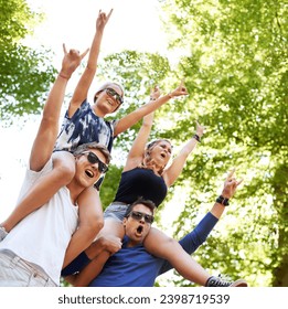 Music, festival and carrying friends on shoulders with cheers of fans in celebration and freedom. Happy, people or sign for rock n roll at concert with trees above or men support girlfriends in woods - Powered by Shutterstock