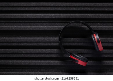 Music headphones and acoustic foam wall background texture. Soundproof material for record studio room