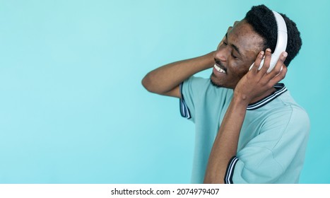 Music inspiration. Happy man. Stereo sound. Smiling guy in white headphones enjoying favorite song isolated blue copy space.