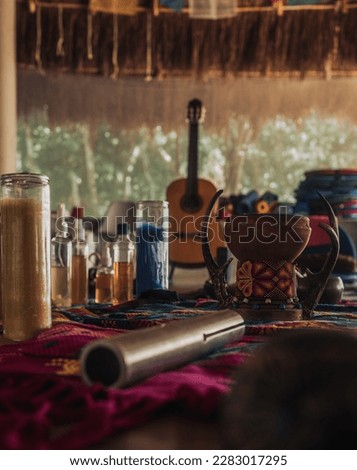 Music instrument and incense burner on a purple blanket with guitar and tropical background in jungle lodge in Tulum during sound healing session on a sunny afternoon