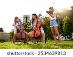 Music, learning and children with violin and cello in park for playing, practice and lesson with teacher. Morning, nature and woman and kids with instruments for talent show, rehearsal or recital