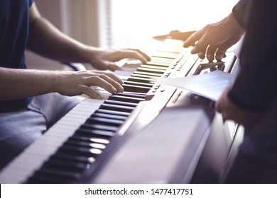 Music lesson and course. Piano teacher and student practising in school. Man learn playing with tutor in class. Two guys training. Mentor teaching pianist. Band practise. Hobby and education concept.