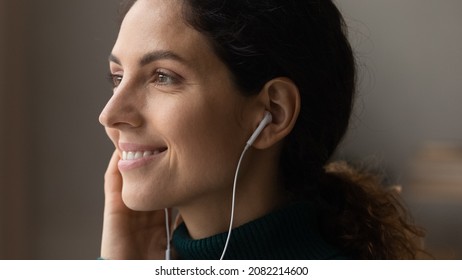 Music lover. Close up of happy young latin female face listening to favorite song in wired earphones smiling enjoying perfect sound quality. Lovely millennial woman enjoy audio book podcast in headset - Shutterstock ID 2082214600