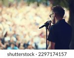 Music, microphone and concert with man at festival for rock, performance and party in nature. Celebration, energy and audience with male singer on stage for club, rave and dj event in outdoors