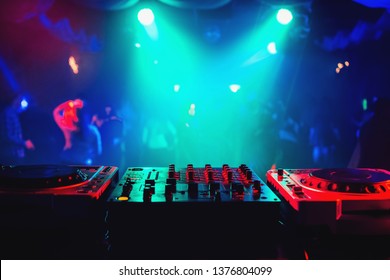 music mixer controller in DJ booth on dance floor background in night club at party