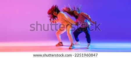 Music in moves. Young expressive hip-hop dancers dancing in neon. Concept of dance, youth, hobby, dynamics, movement, action, ad. Banner with copy space