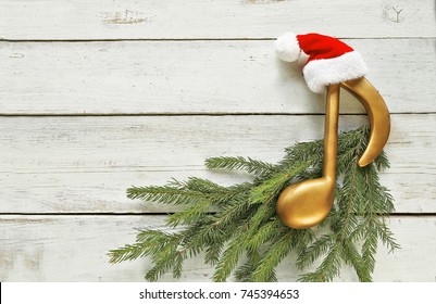 Music Note With Santa Hat  On Christmas Tree Branch On Wooden 