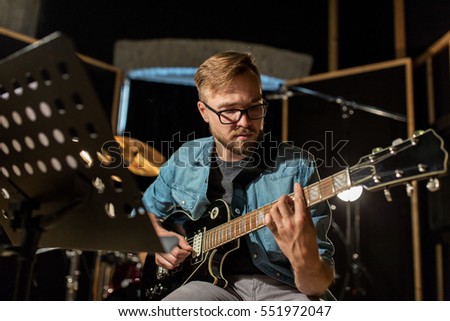 Foto Bild Mann spielt auf E-Gitarre vor dunklem Hintergrund, Nahaufnahme