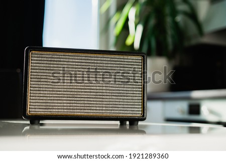 Music is playing. A vintage radio sits on a white table in the kitchen. Stylish music radio channel receiver. Accepts the melody of the Bluetooth channel Wi-Fi connection.