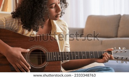 Music practice. Guitar leisure. Female player. Concentrated woman guitarist playing song on string acoustic instrument at home room.