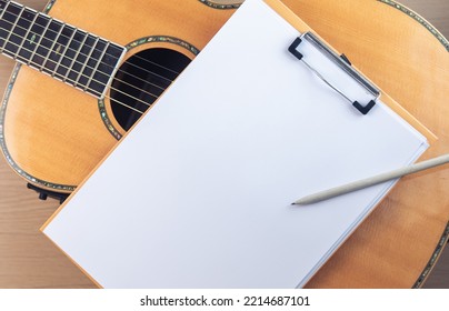 Music Recording Scene With Guitar, Empty Music Sheet And Pencil On Wooden Table