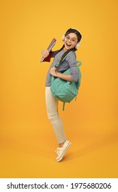 Music school. Happy girl back to school. Schoolchild carry backpack yellow background. School and education. Knowledge day. September 1. Startup. First day of school. Always learning