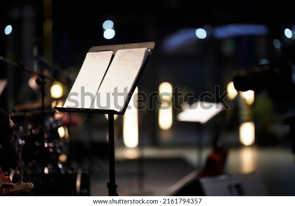 music stand with musical score on\
a blurred background. musical score on a music stand,\
close-up