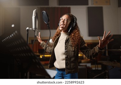 Music, streaming and woman recording in studio in home, singing into microphone with headphones and talent. Technology, art and creative influencer or musician with live stream song for record label. - Shutterstock ID 2258992623