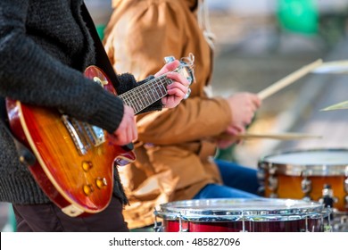 Music street performers on autumn outdoor. Middle section of body part with guitar.