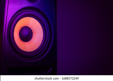 Music studio speaker, with a yellow membrane, isolated on a dark purple background, with space for text on the right side. Electronic music concept. - Powered by Shutterstock