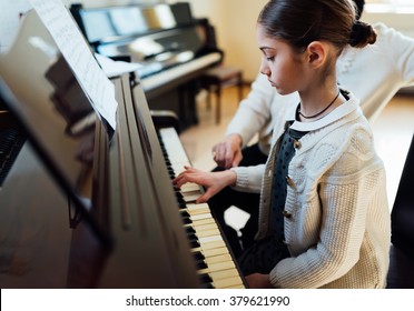 A Music Teacher With The Pupil At The Lesson Piano