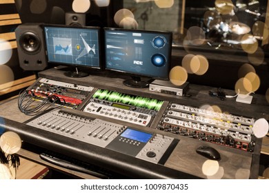 Music, Technology, Electronics And Equipment Concept - Mixing Console And Computer Monitors At Sound Recording Studio Over Lights