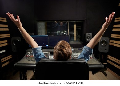 Music, Technology, People And Equipment Concept - Happy Man At Mixing Console In Sound Recording Studio