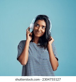 Music, young Indian woman with headphones and smile in studio background. Technology or entertainment, sound track and happy female person listen to radio or audio podcast isolated in backdrop - Powered by Shutterstock