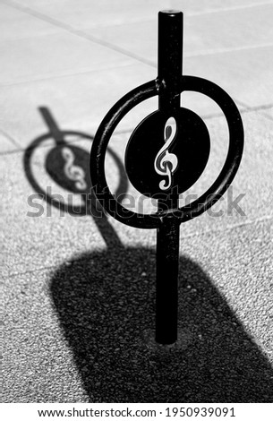 Musical clef  in a sign on the street with a shadow