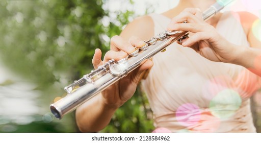 Musical concept : Closeup of flute player asian female artist superstar playing flute with classical melodies playing flute in happy garden. - Shutterstock ID 2128584962