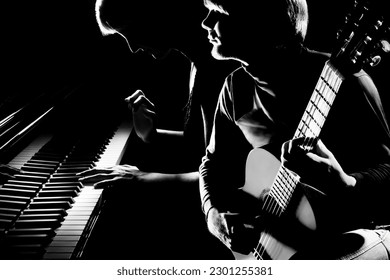 Musical duet piano and acoustic guitar player. Pianist and guitarist classical musicians playing music instruments concert