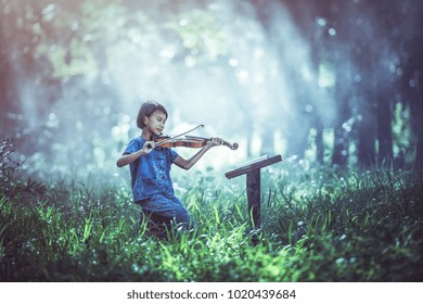 The Musical: Little Asian Child Playing Violin At Outdoors