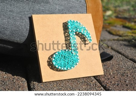 A musical note made from a board and string
