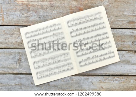 Musical notes book on rustic background. Musical papers on vintage wooden boards.