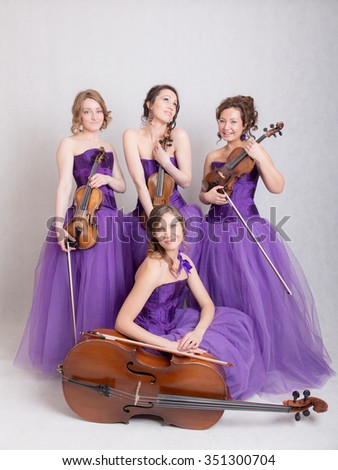 musical quartet in evening dresses with strings instruments