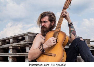 musical romantic ballade. musical string instrument. mature charismatic male guitarist. guy with beard and moustache play guitar. bearded man in checkered shirt sing song. music performer musician.