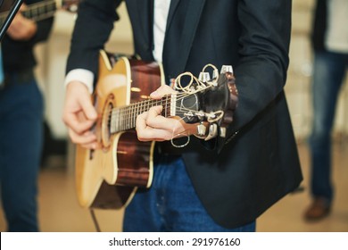 A Musician In Blue Jeans And A Jacket Plays A Cool Acoustic Guitar At A Wedding With A Music Band