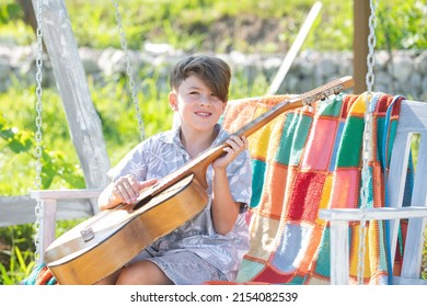 Musician Child Playing Guitar. Kid Boy Singing And Playing Guitar Outside. Kids Music And Songs.