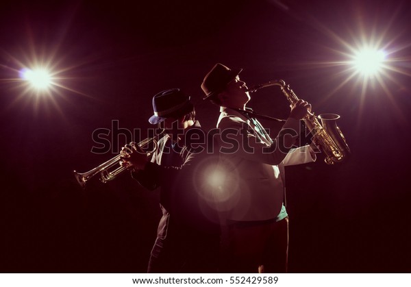 Musician Duo band playing the\
Trumpet with spot light and lens flare on the stage, musical\
concept