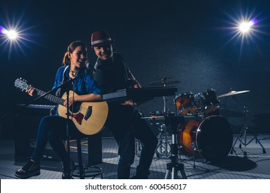 Musician duo band singing a song and playing music instrument with Fellow band musicians on black background with spot light and lens flare, musical concept - Powered by Shutterstock