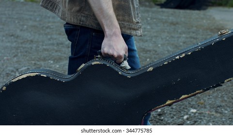 The Musician Goes With The Guitar In The Case.