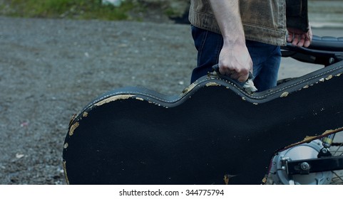 The Musician Goes With The Guitar In The Case.