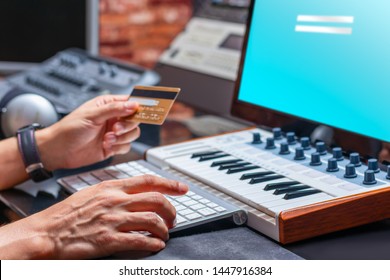 musician hands holding credit card for online shopping in music studio